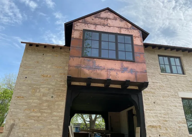 Copper metal panel facade on a stone building for Metal Roof Coating in Louisburg